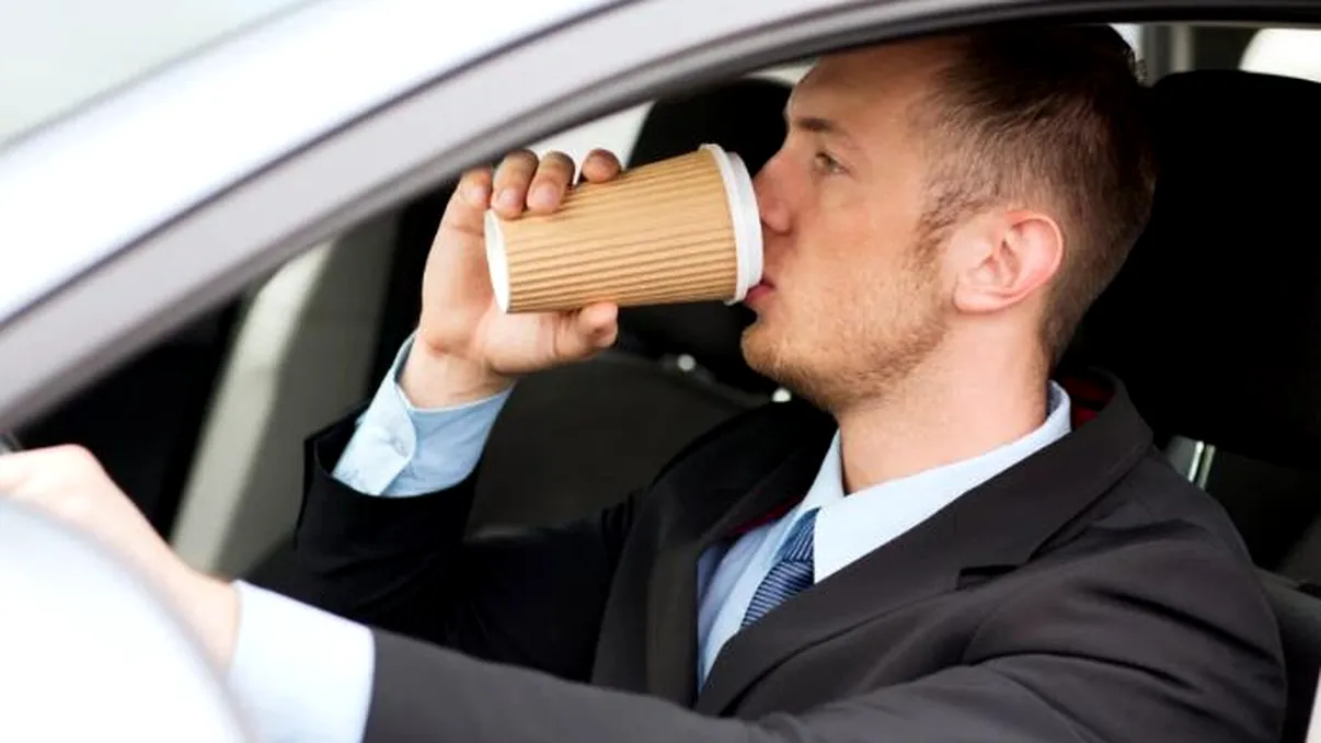 Ai voie să bei apă sau cafea în maşină? Ce spune legea despre luatul mâinilor de pe volan