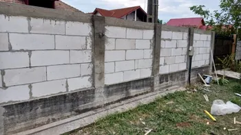 O femeie din Constanța și-a construit un gard de 5 metri fără autorizație de la primărie. Judecătorii o obligă acum să-l desființeze