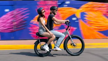 Doi oameni pe o bicicletă electrică: trucurile simple care te scapă de accidente și amenzi