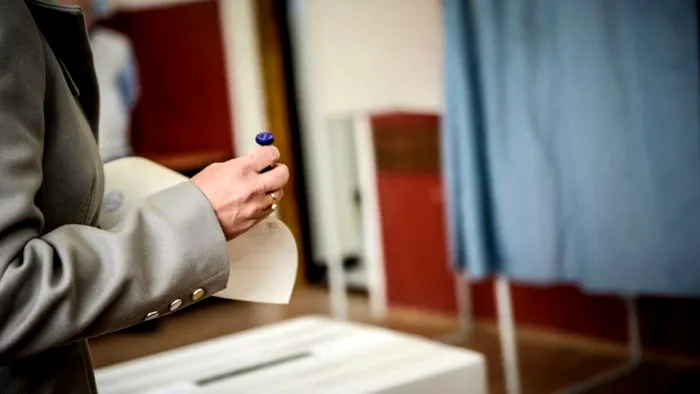 Persoană cu buletin de vot în mână