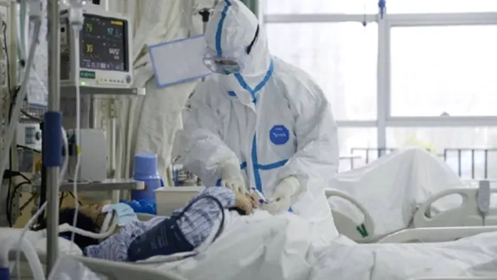 Medic care ingrijeste un pacient bolnav de coronavirus