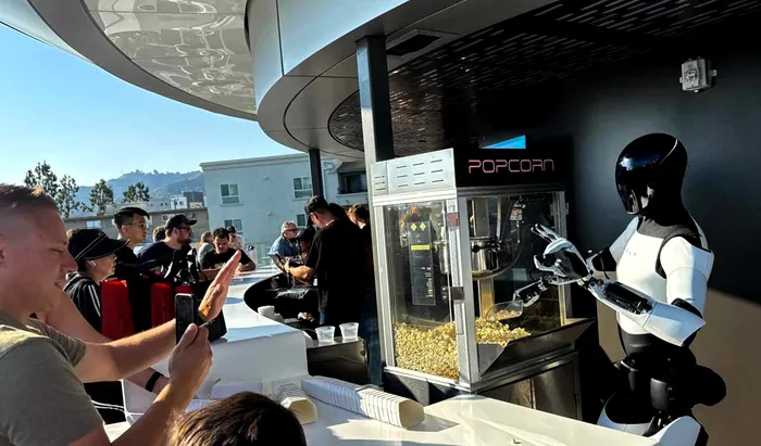 Imagine cu robotul Optimus servind popcorn în fața restaurantului Tesla Diner din Los Angeles.