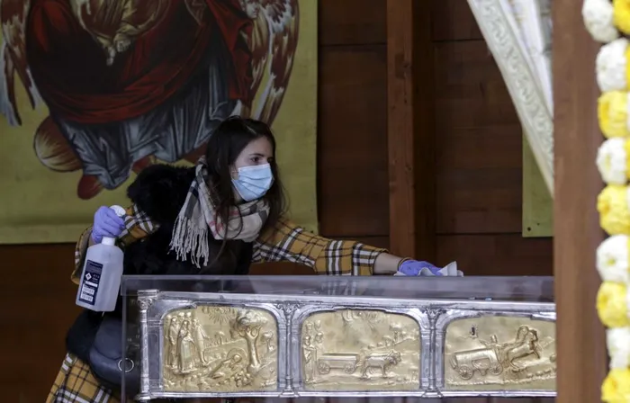 Credincioasă atingând racla cu moaștele Sfântului Dumitru.