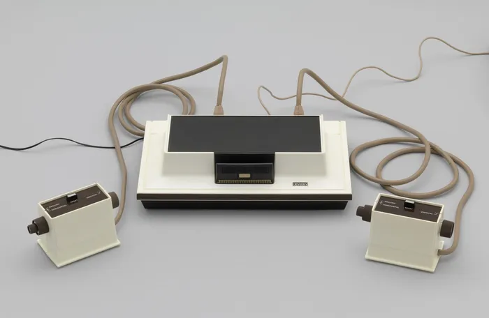 Magnavox Odyssey, consola lansată în 1972, cu unitatea centrală și cele două controllere care au transformat televizorul într-un dispozitiv interactiv.