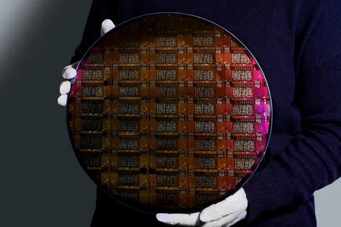 Un cercetător IBM ține în mână waferul