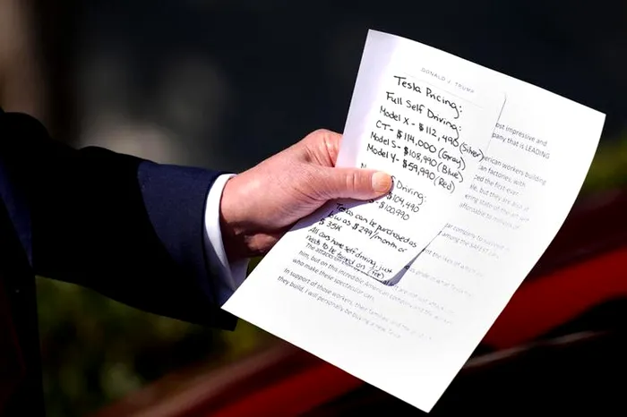 Donald Trump ținând în mână notițe.
