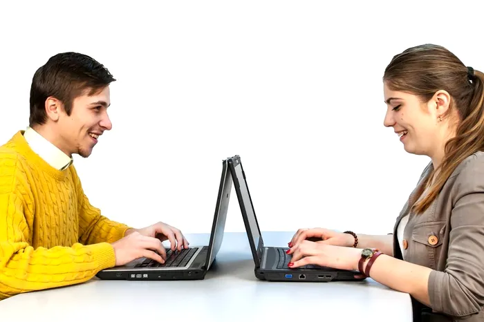 Doi studenți care caută informații pe laptopuri.