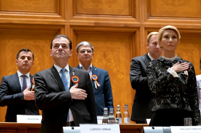 Ludovic Orban și alți miniștri ținând mâna la piept