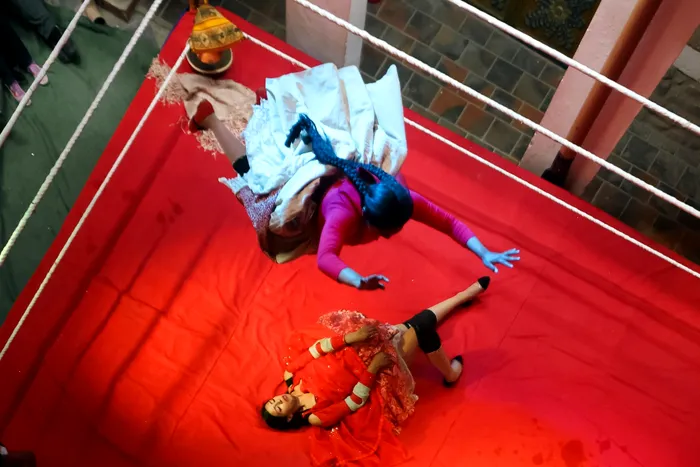 O luptătoare zboară peste adversara ei într-un meci de wrestling