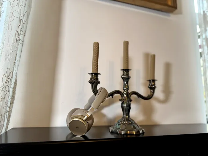 Bang & Olufsen Beoplay H100 sprijinite pe un sfeșnic - foto: Playtech.ro