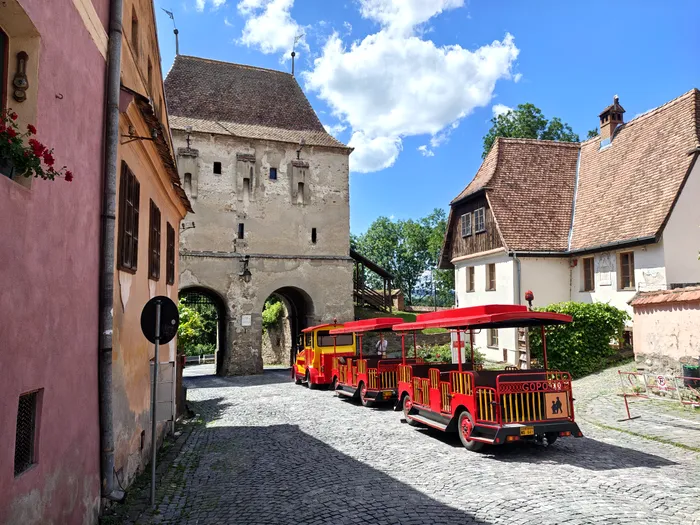 Trenulețul electric face contrast cu zidurile medievale ale Cetății Sighișoara, dar tot pare o sursă de bucurie, mai ales pentru tânăra generație / foto: Playtech